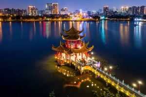 Traditional chinese pagoda, Spring and Autumn Pavilions, at night with Kaohsiung city in the background, Taiwan