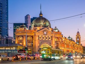 Flinders Street Railway Station with moving tram in sunset, Melbourne, Victoria, Australia