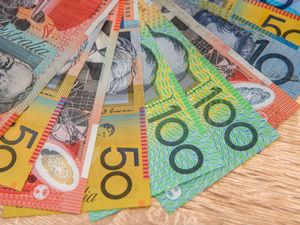 Close up picture of colorful national Australian Dollar banknotes on a wooden table.
